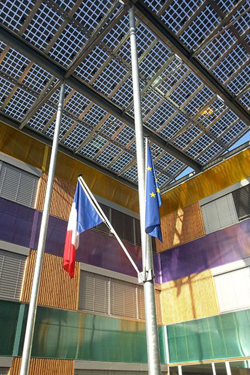 Le drapeau de la France et de l'union européenne accrochés sous la verrière de panneaux solaires